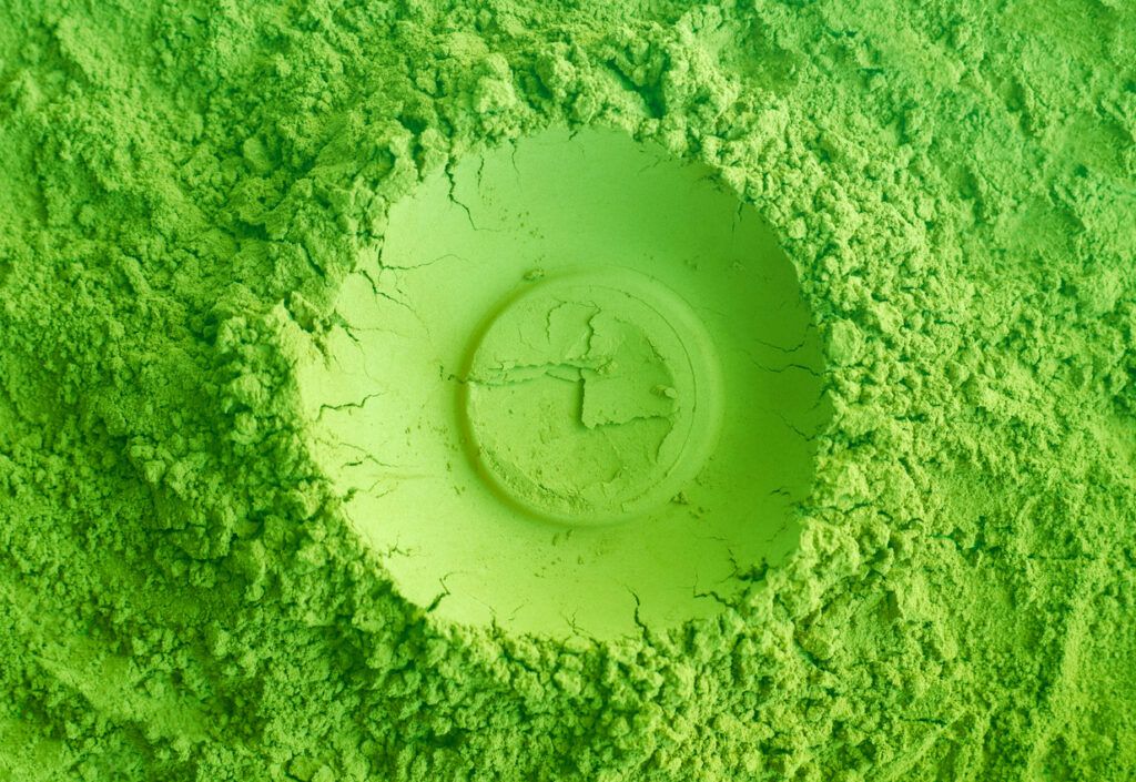 Green tea matcha powder texture close up, selective focus. Abstract background.